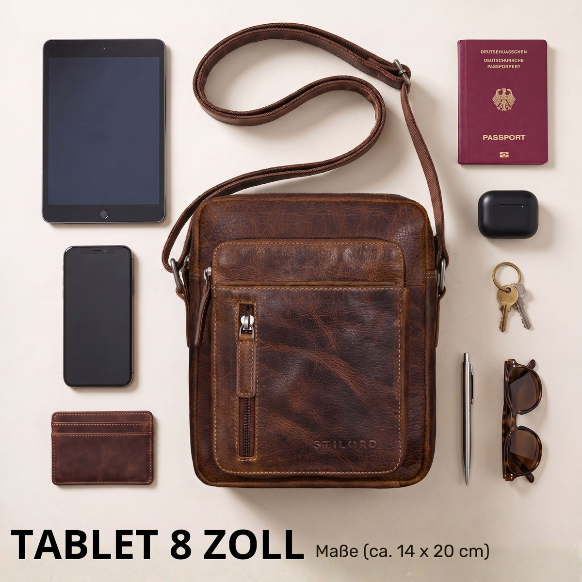 Top-down Ansicht einer kleinen braunen Leder-Umhängetasche salerno mit STILORD-Prägung, Zubehör und 8-Zoll-Tabletmaß