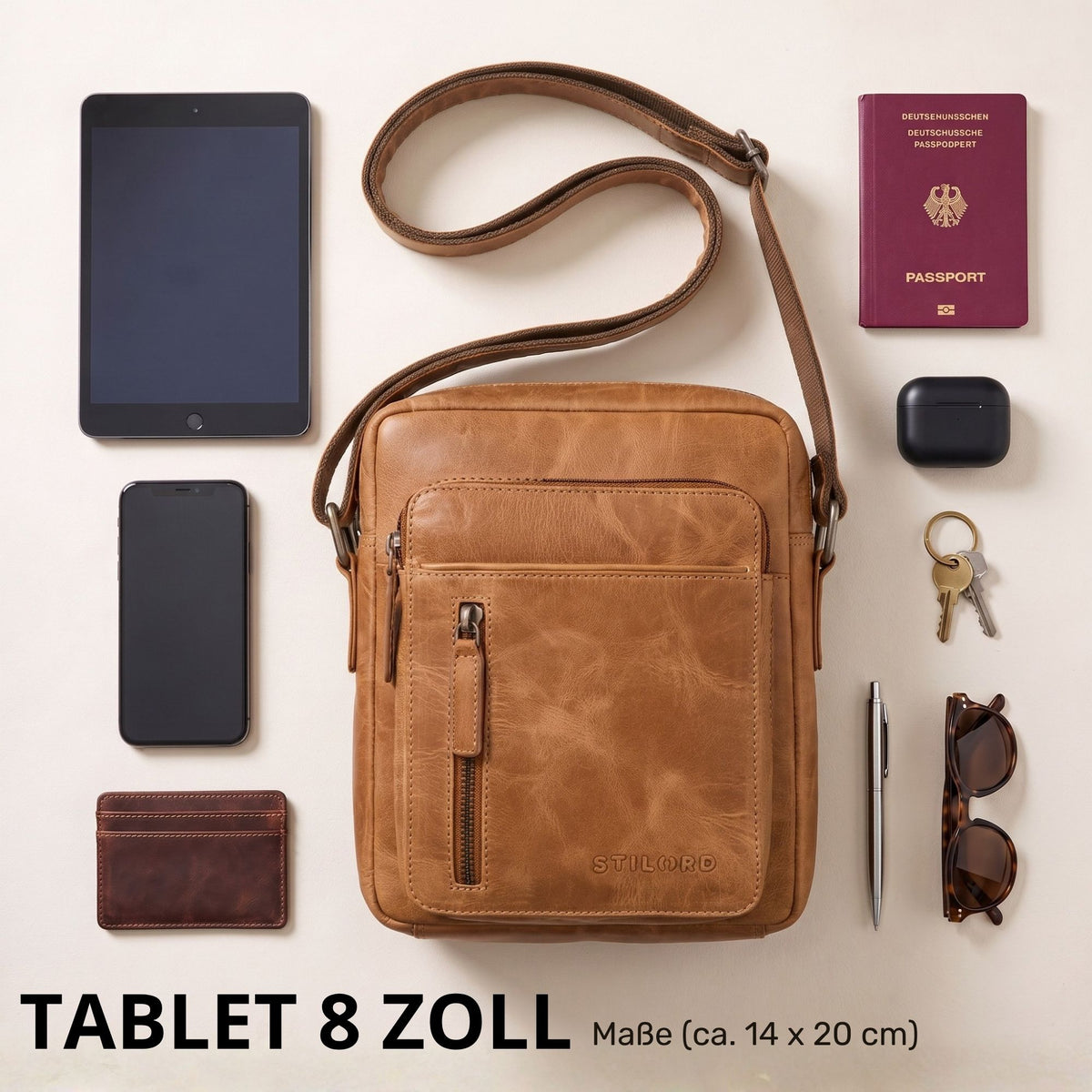 Kleine Herrenschultertasche aus Leder in perugia-braun, Frontalaufnahme mit 8-Zoll-Tablet und Alltagsgegenständen