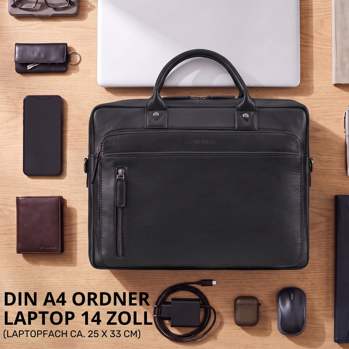 Schwarze Leder-Business-Tasche mit Laptopfach 13-14 Zoll, frontale Ansicht auf Holztisch mit Zubehör, STILORD-Prägung sichtbar