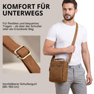 Kleine Leder-Umhängetasche tan mit Henkel und verstellbarem Schultergurt, Mann trägt sie crossbody, STILORD-Prägung sichtbar